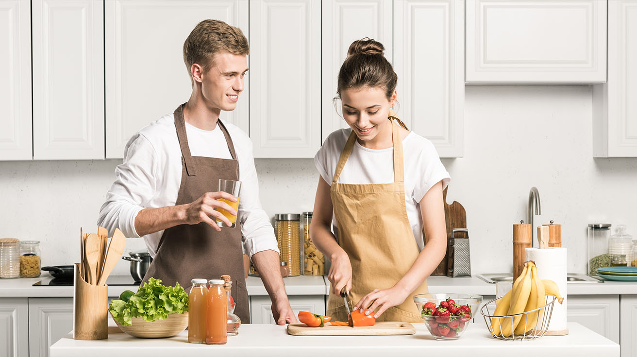 Couple de jeunes mariés à un cours de cuisine