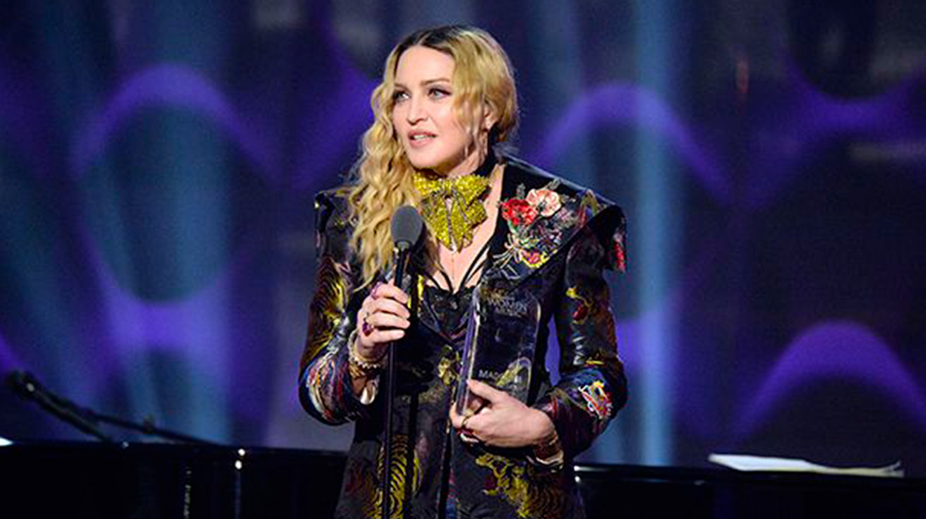 Madonna delivering a powerful speech embodying her Mercury in Virgo’s precision and intellect.